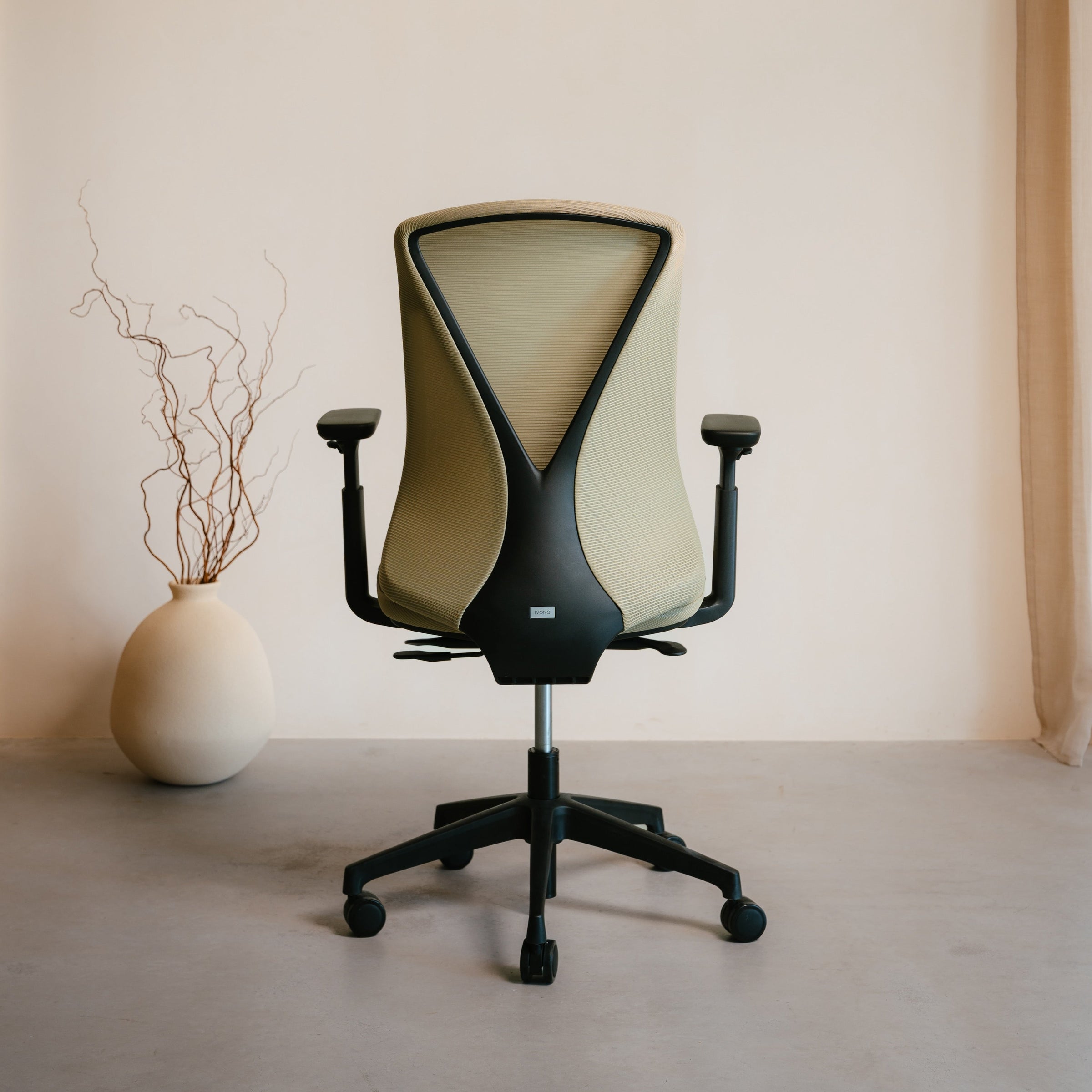 Modern office chair with a minimalistic design against a plain wall.