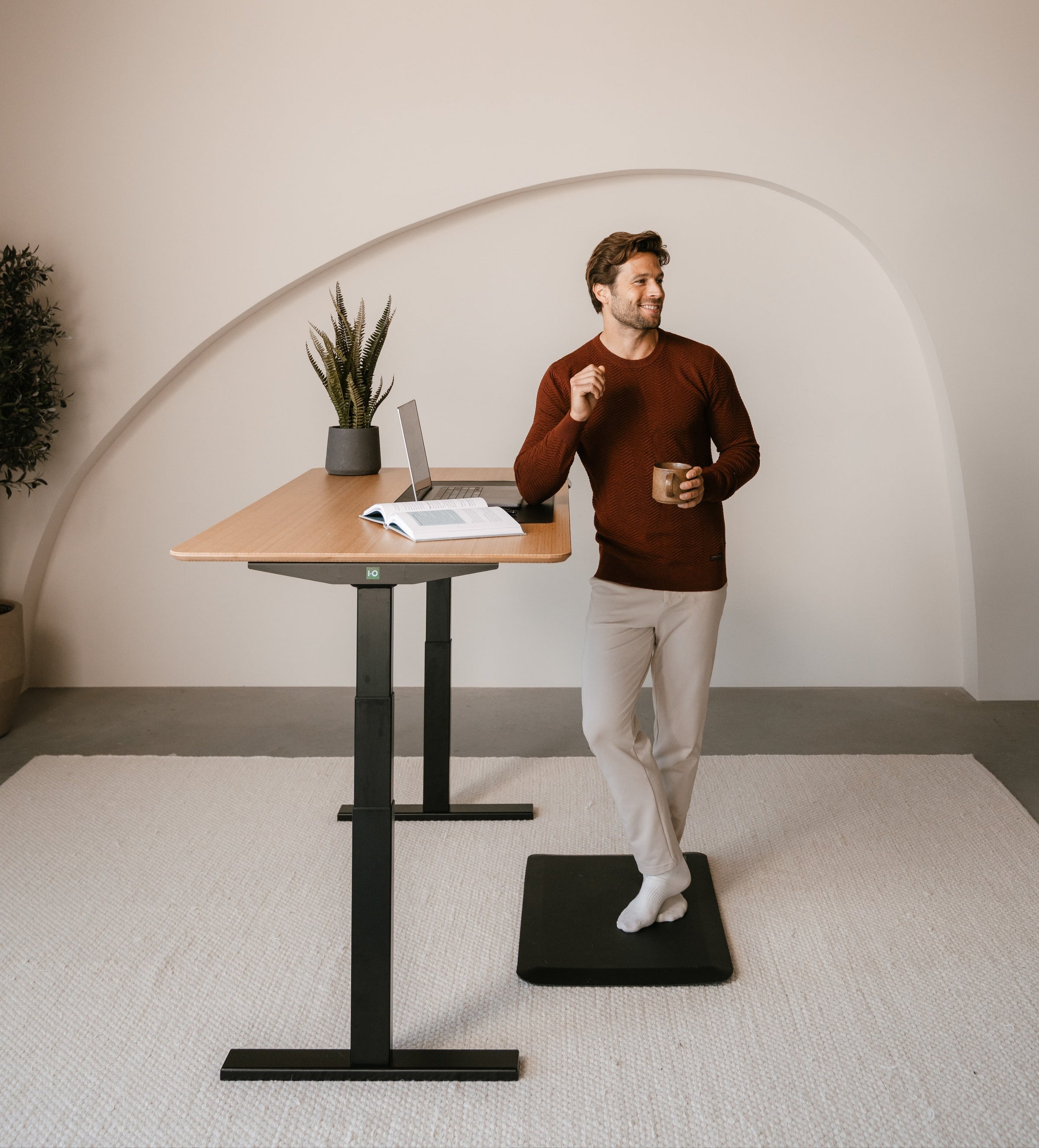 Man using a standing desk in a minimalistic room.